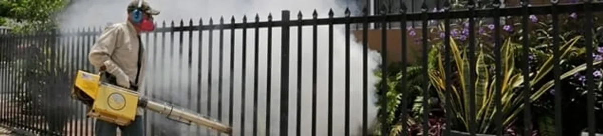 Mosquito control technician fogging a yard perimeter for mosquito reduction in Kansas City, KS